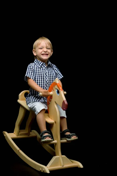 一个小男孩骑着一匹木马 — 图库照片