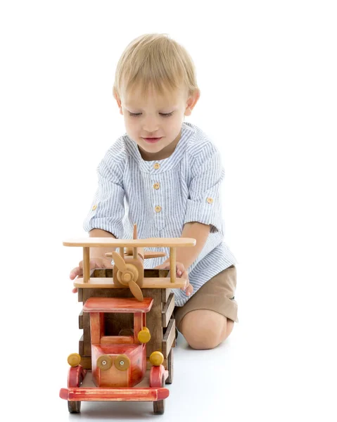 小男孩正在玩一辆木车。. — 图库照片