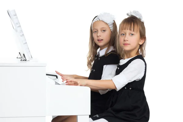 As raparigas tocam piano. Isolado sobre fundo branco — Fotografia de Stock