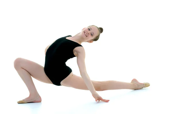 Die kleine Turnerin führt ein akrobatisches Element am Boden auf. — Stockfoto