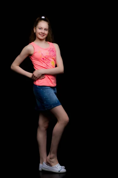 Fashionable girl teenager studio photo on a black background. — Stock Photo, Image