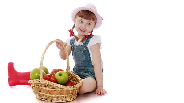 Bambina con un cesto di mele. Isolata su sfondo bianco — Foto Stock