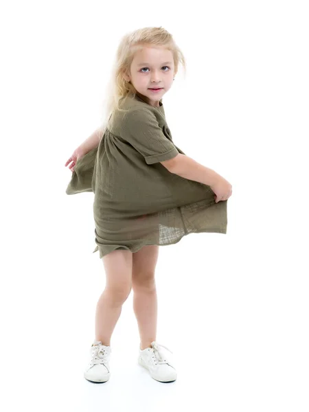 一个穿着裙子的小女孩在纺纱. — 图库照片
