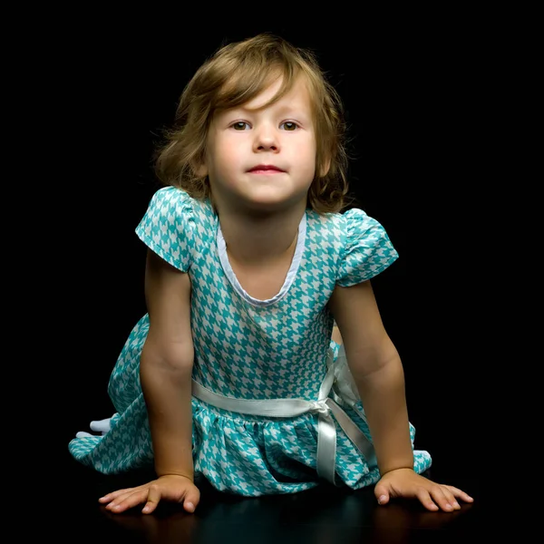 Cute Little Girl leżącego na podłodze w studiu na czarnym BAC — Zdjęcie stockowe