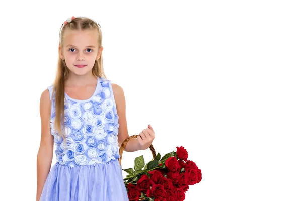 Schattig klein meisje met een mandje met bloemen. — Stockfoto