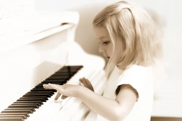 La ragazza è al pianoforte a coda bianco. — Foto Stock