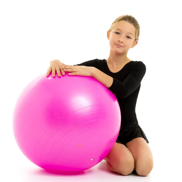 Niña haciendo ejercicios en una pelota grande para la aptitud. — Foto de Stock