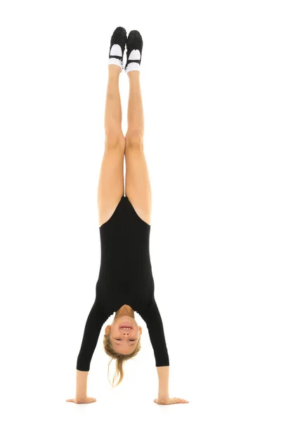 The gymnast performs a handstand with bent legs. Stock Photo