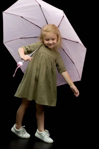 Kleines Mädchen unter einem Regenschirm. Schutz vor schlechtem Wetter. — Stockfoto