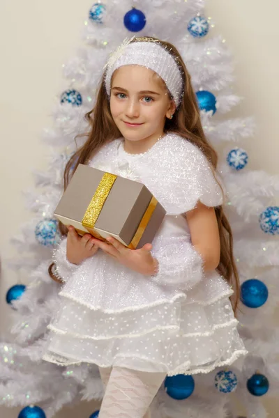 Little girl near the Christmas tree with a gift. — Stock Photo, Image