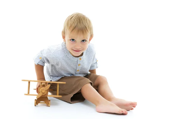 Liten pojke leker med träplan — Stockfoto