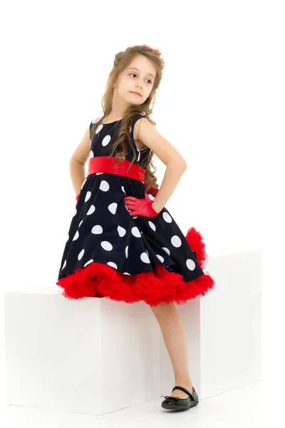 Chica en vestido de lunares, guantes rojos y arco de pie mirando Awa —  Fotos de Stock