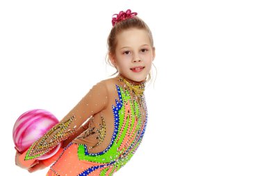 Kız jimnastikçi, topla egzersiz yapıyor..