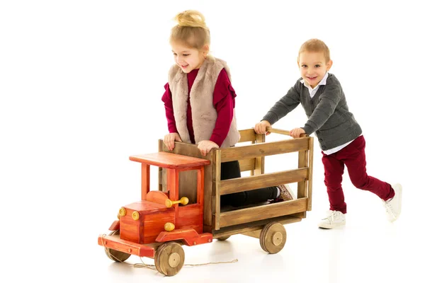 Hermano y hermana están jugando con un coche de juguete . —  Fotos de Stock