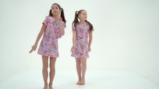 Twee vrolijke kleine meisjes dansen. Het concept van kinderen — Stockvideo