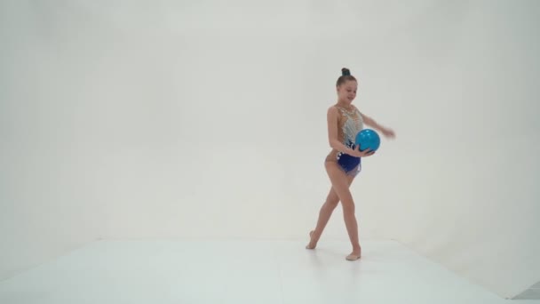 Lány tornász elvégzi gyakorlatok a labdát. — Stock videók