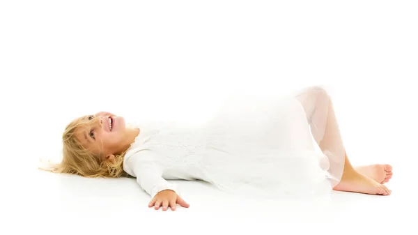 Little girl lies on the floor.Studio photo shoot on a white back — Stock Photo, Image