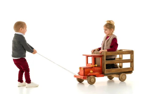 Hermano y hermana están jugando con un coche de juguete . — Foto de Stock