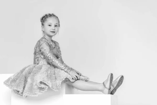 Nettes kleines Mädchen sitzt im Studio auf der weißen Treppe. Stil und Modekonzept, glückliche Kindheit. — Stockfoto