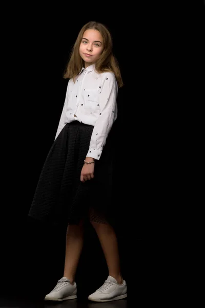 Fashionable girl teenager studio photo on a black background. — Stock Photo, Image