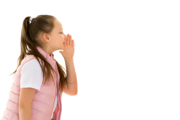 Una niña dice algo en secreto mientras se cubre la boca con las manos. —  Fotos de Stock