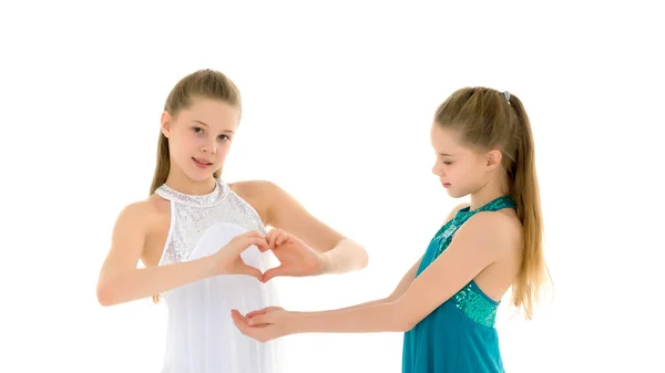 Dos chicas adorables gimnastas doblaron las palmas en forma de corazón —  Fotos de Stock