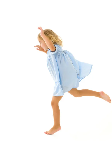 Söt liten flicka kul springa runt i rummet. Koncept för barnlekar — Stockfoto