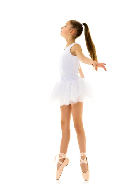 एक ट्यू आणि पॉइंट शूज मध्ये सुंदर लहान मुलगी पांढरा पार्श्वभूमीवर स्टुडिओ मध्ये नृत्य . — स्टॉक फोटो, इमेज