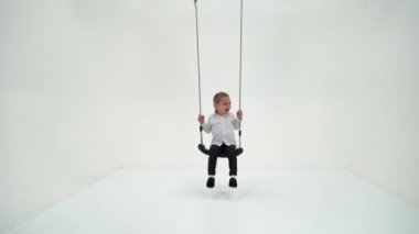 Sevimli Sarışın Çocuk İp Sallanıyor ve Kameraya Bakıyor