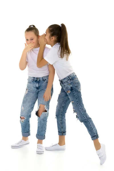 Dwie wesołe dziewczynki dzielą się sekretami w uszach. — Zdjęcie stockowe