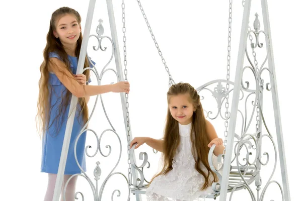 Meninas balançar em um balanço.Isolado no fundo branco. — Fotografia de Stock