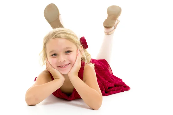 Petite fille se trouve sur le plancher.Studio séance photo sur un fond blanc . — Photo