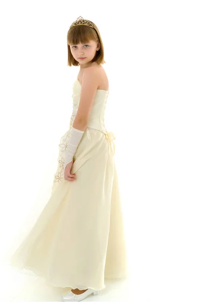 En liten flicka i en lång, elegant klänning av en prinsessa. — Stockfoto
