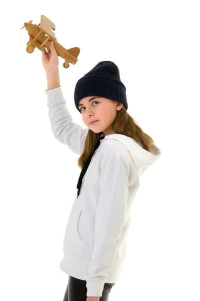 Маленькая девочка играет с деревянным самолетом. — стоковое фото