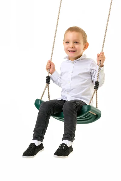 Carino biondo ragazzo oscillando su corda swing e guardando fotocamera — Foto Stock