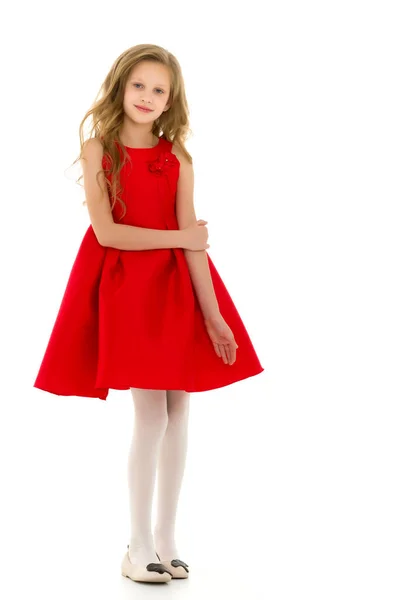 Schöne Mädchen in einem roten Kleid steht und lächelt in die Kamera — Stockfoto