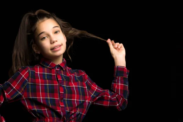 Una hermosa niña endereza su cabello en su cabeza. —  Fotos de Stock