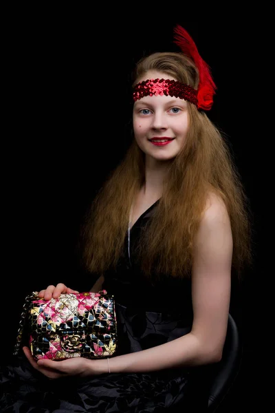 Niña adolescente de moda con un bolso en las manos. Sobre un fondo negro . —  Fotos de Stock