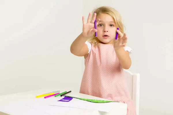 Une petite fille dessine à la table . — Photo