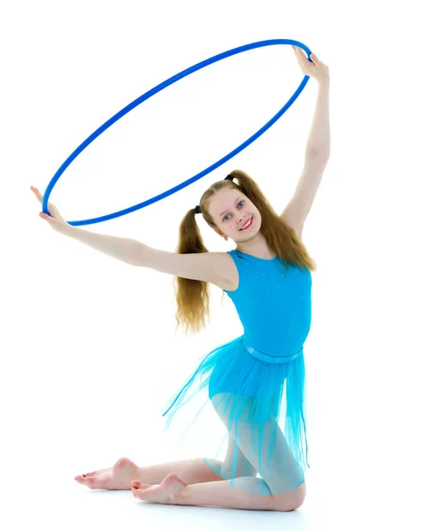 Una chica gimnasta realiza un ejercicio con un aro . — Foto de Stock