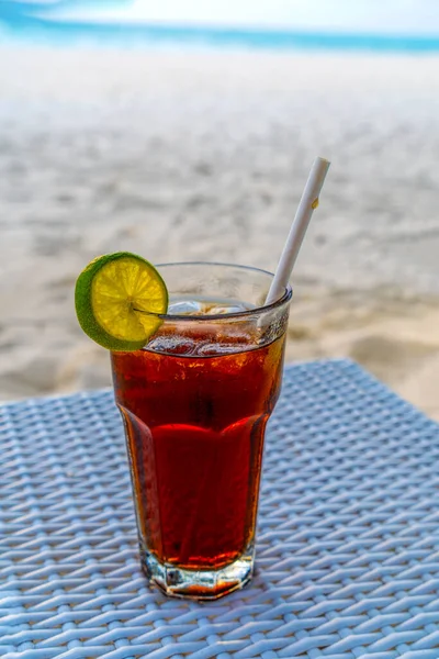 A glass of cold cocktail on a table on the beach in a restaurant. Maldives — Stock Photo, Image