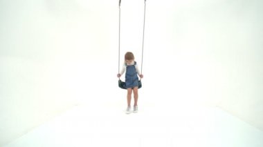 Güzel Sarışın Kız İp Sallanıyor ve Kameraya Bakıyor