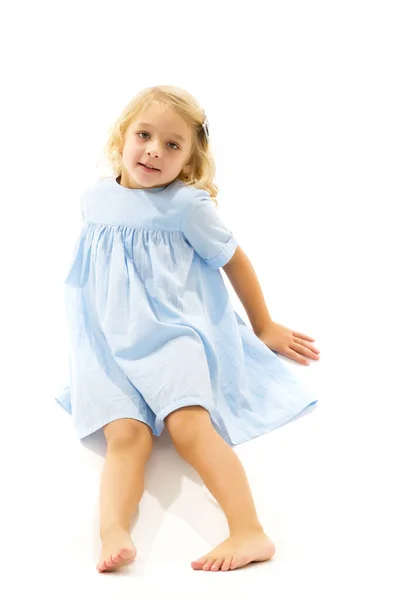 Klein meisje zit op de vloer. Het concept van een gelukkige jeugd.. — Stockfoto