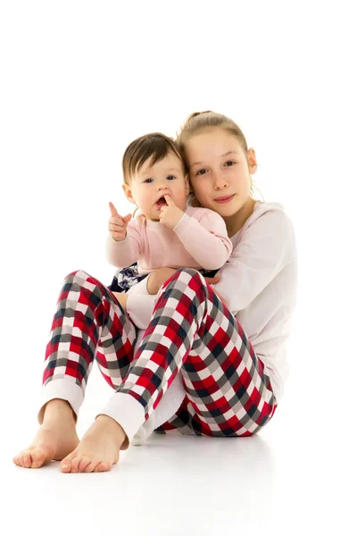 Zwei Mädchen unterschiedlichen Alters im Studio auf weißem Hintergrund. — Stockfoto