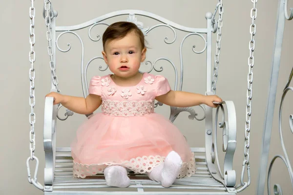 Feliz niña colegiala balanceándose en un columpio. — Foto de Stock