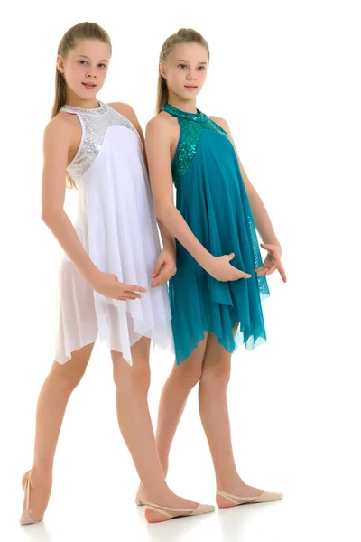 Дві сестри - близнюки танцюють у білій і блакитній спортивній сукнях — стокове фото