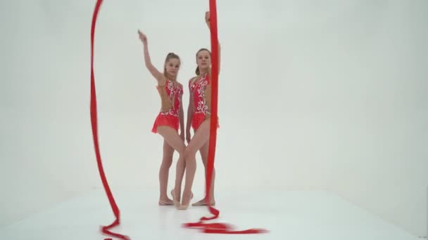 Two girl gymnast performs exercises with tape. — Stock Video