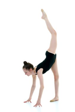 Jimnastikçi yerde akrobatik bir element sergiliyor..