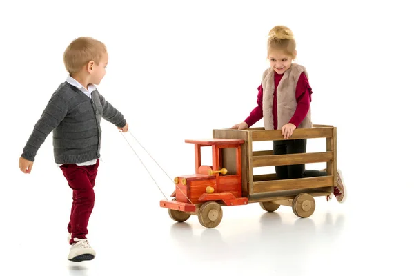 Broer en zus spelen met een speelgoedauto. — Stockfoto