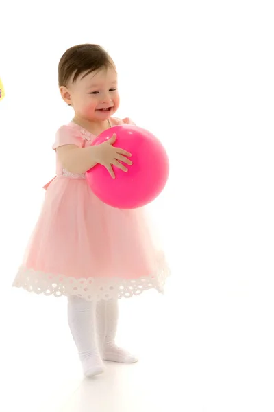 Klein meisje speelt met een bal. Het concept van kindersport, zomer outdoor recreatie. — Stockfoto